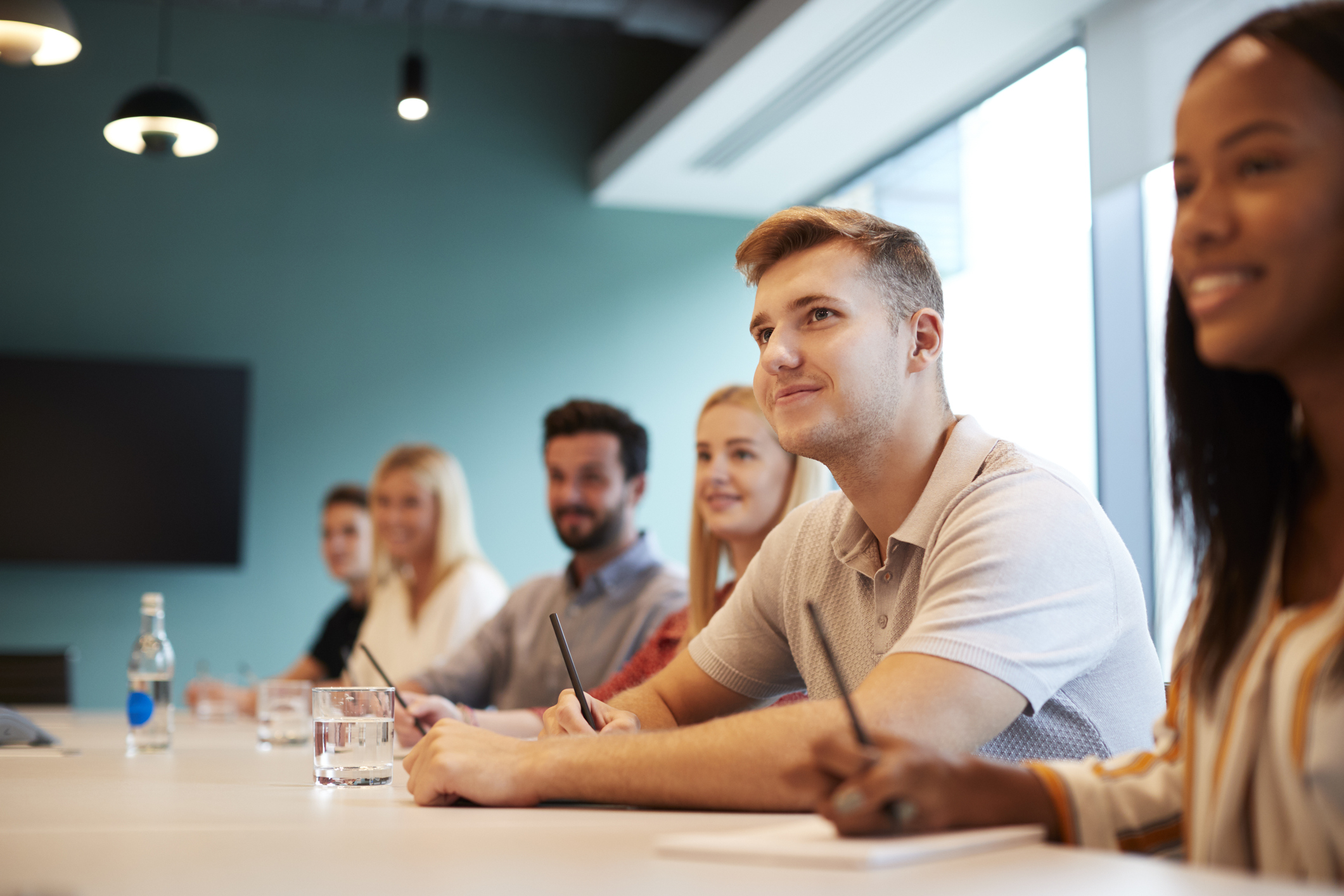 Photo of a group of young interns sitting at a table in an office