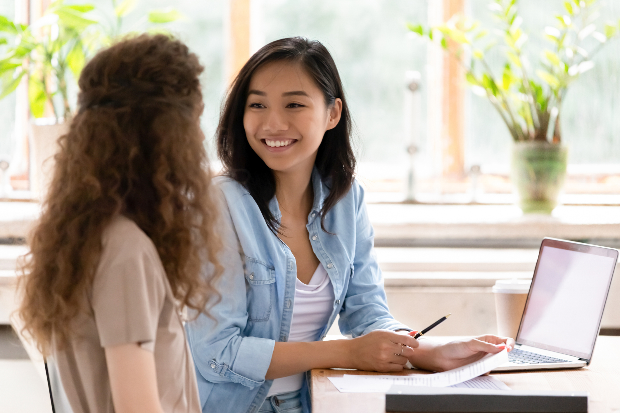 Photo of a job interview between two women sitting at a table.