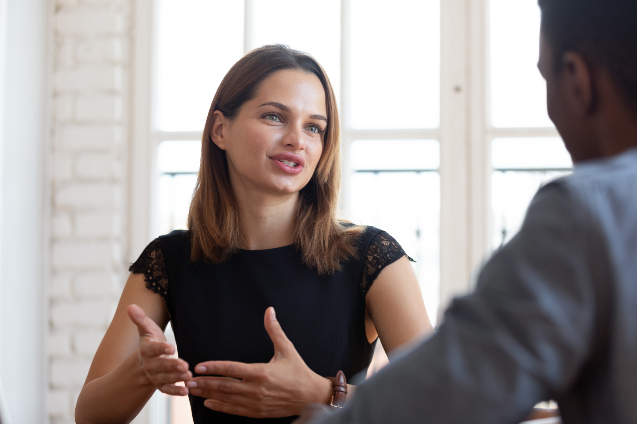 Photo of head shot focus on happy pleasant young female financial advisor with a client.