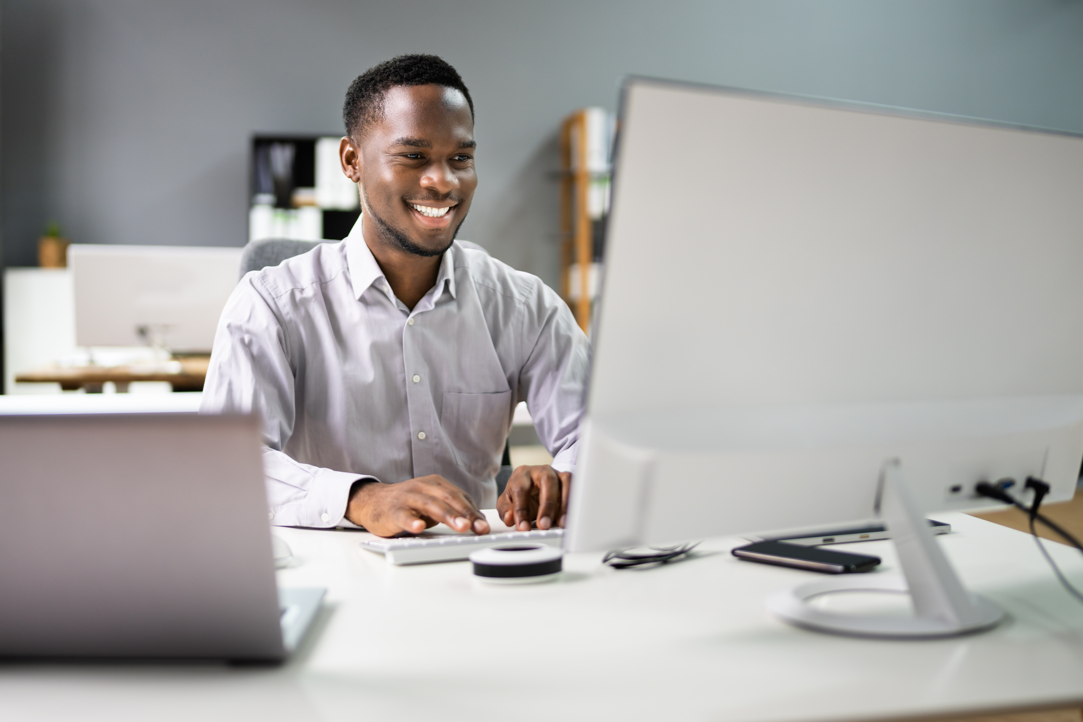 Photo of happy professional man/employee using a computer for work