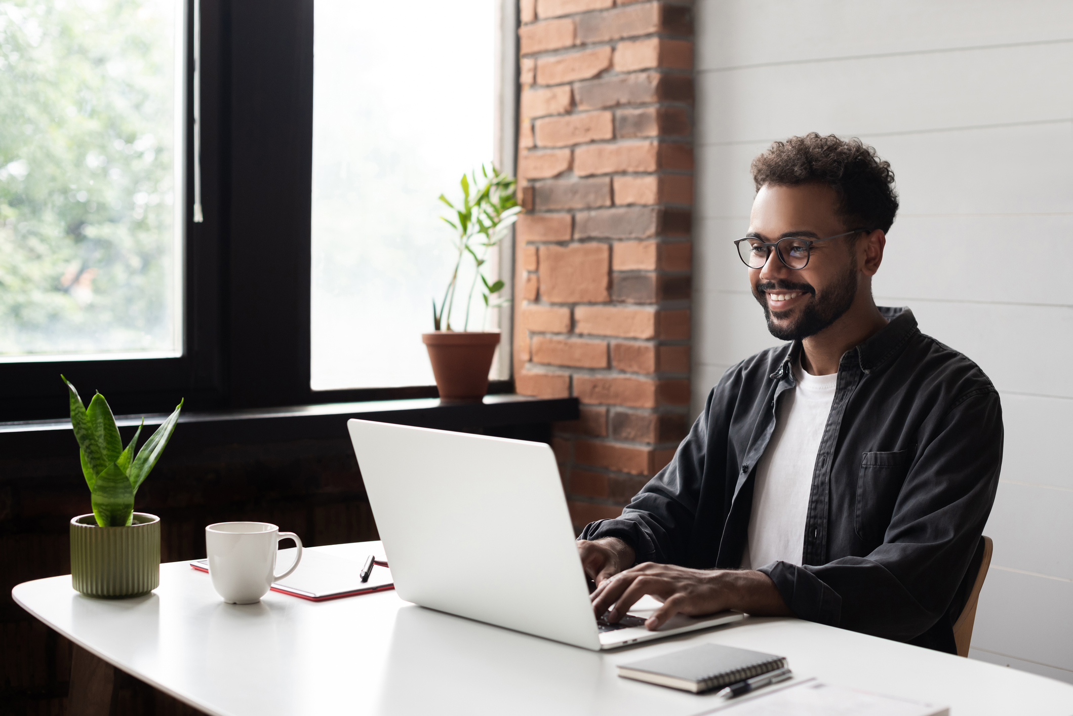 Photo of young businessman using laptop computer in office.