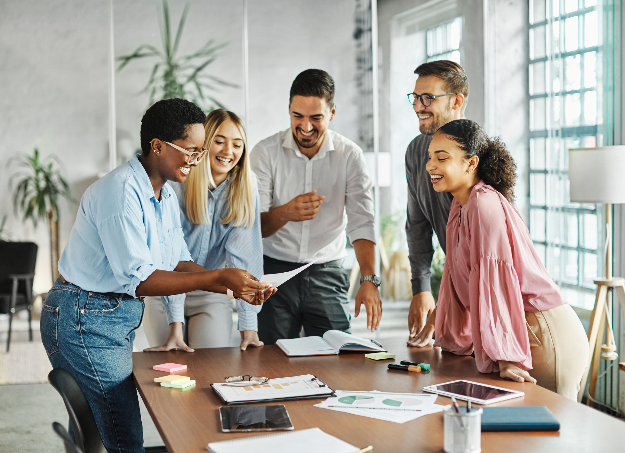 Photo of a happy team of individuals working in an office.