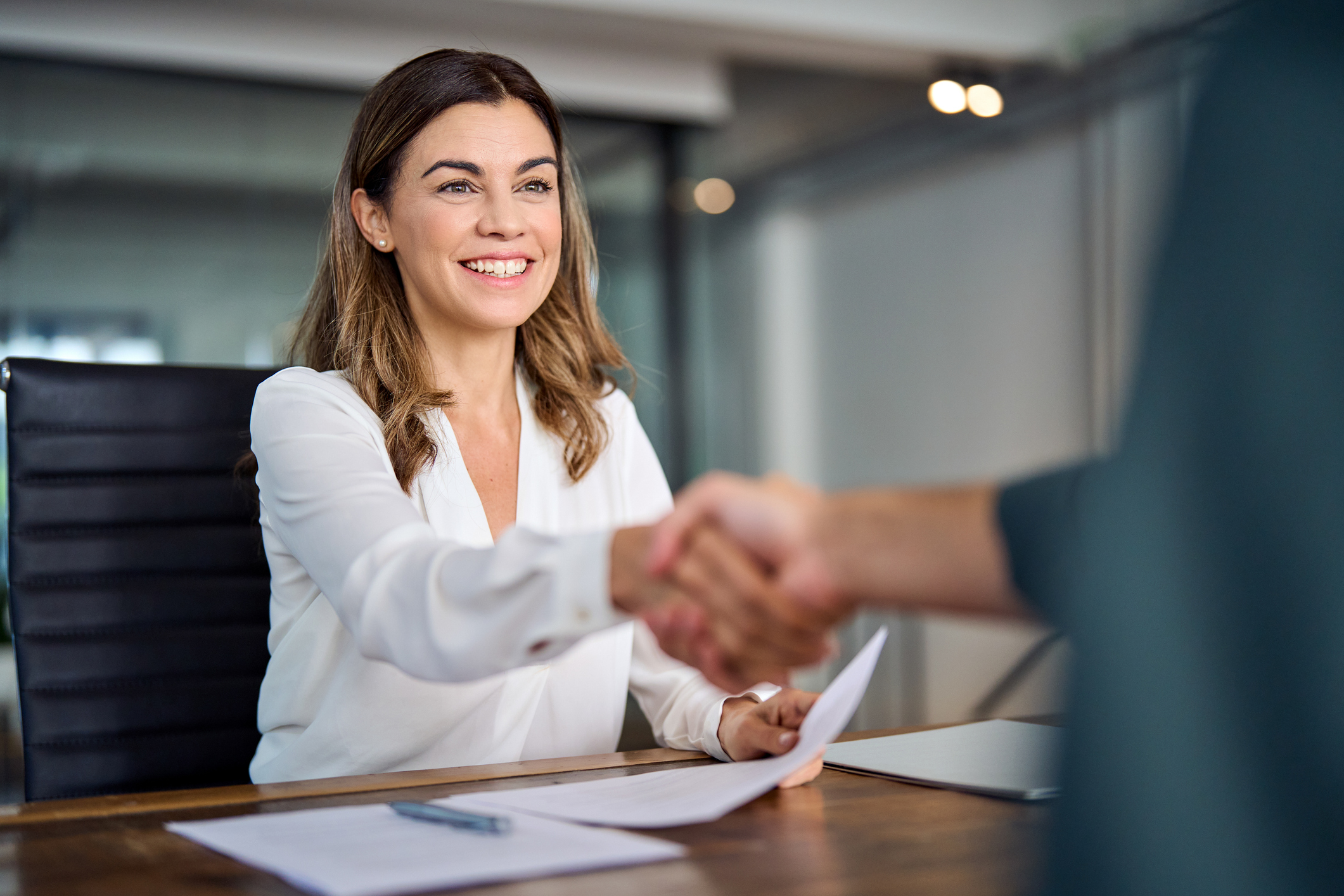 Photo of happy mid aged business woman manager handshaking at office meeting