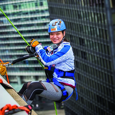 Photo of JoAnna scaling a building in downtown Chicago to raise money for Chicago Youth Centers