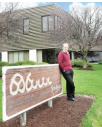 Taylor-Aschliman-Sign Taylor Aschliman in front of Pretzels, Inc.