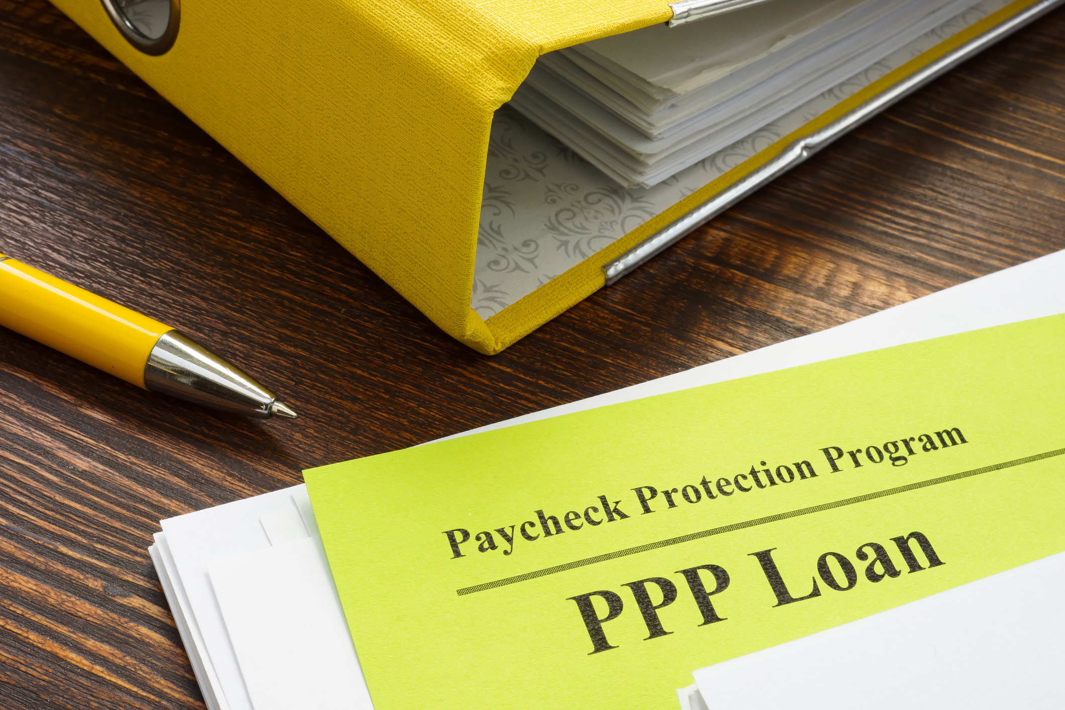 Photo of Paycheck Protection Program or PPP loan papers and yellow folder.